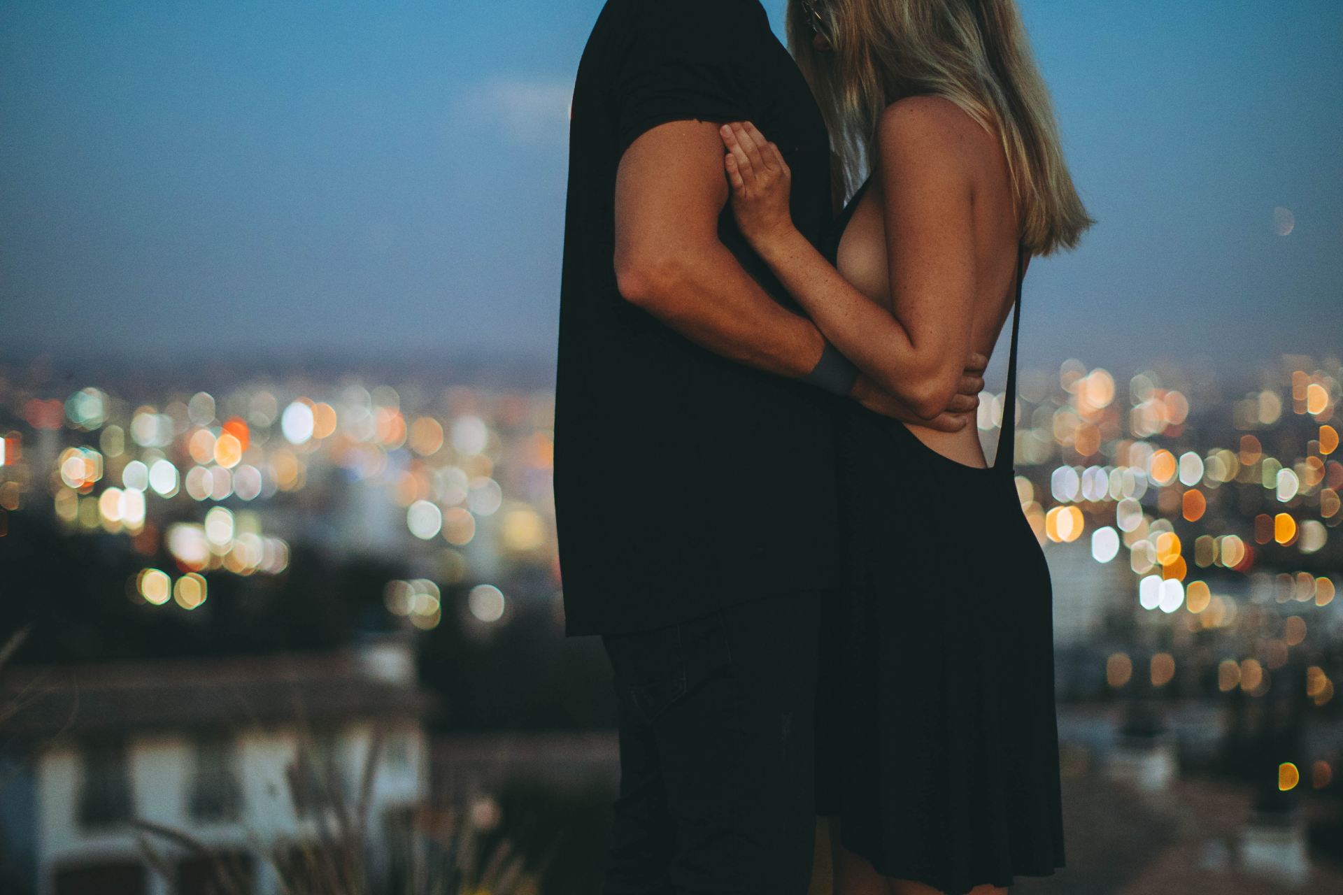 man hugging woman on top of hill during nighttime