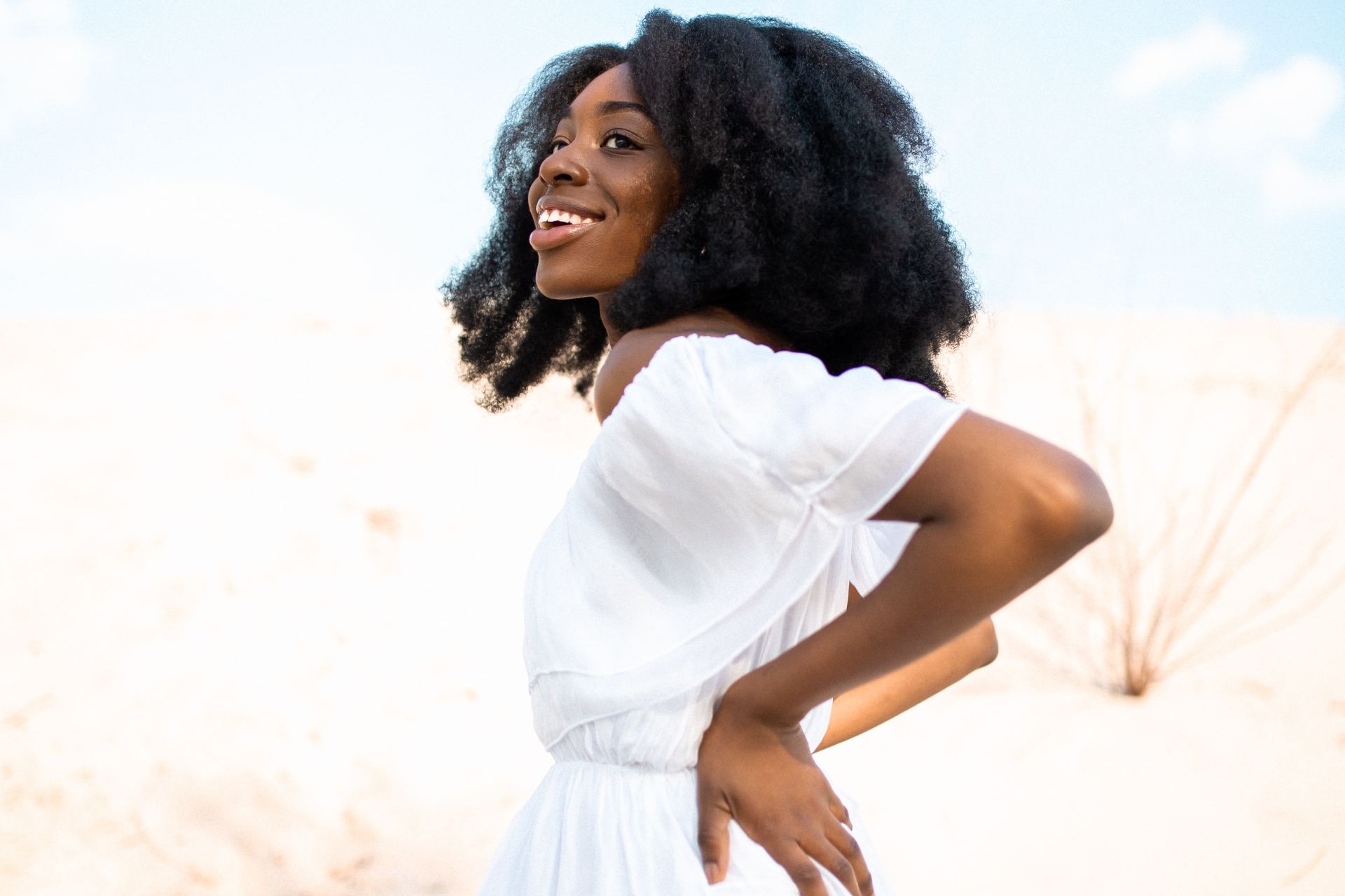 woman wearing white dress with hands on waists