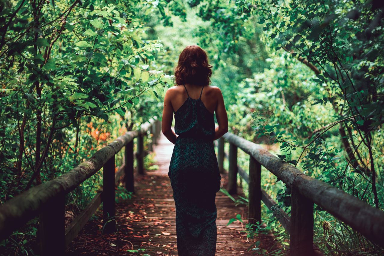 woman in black dress standing on bridge