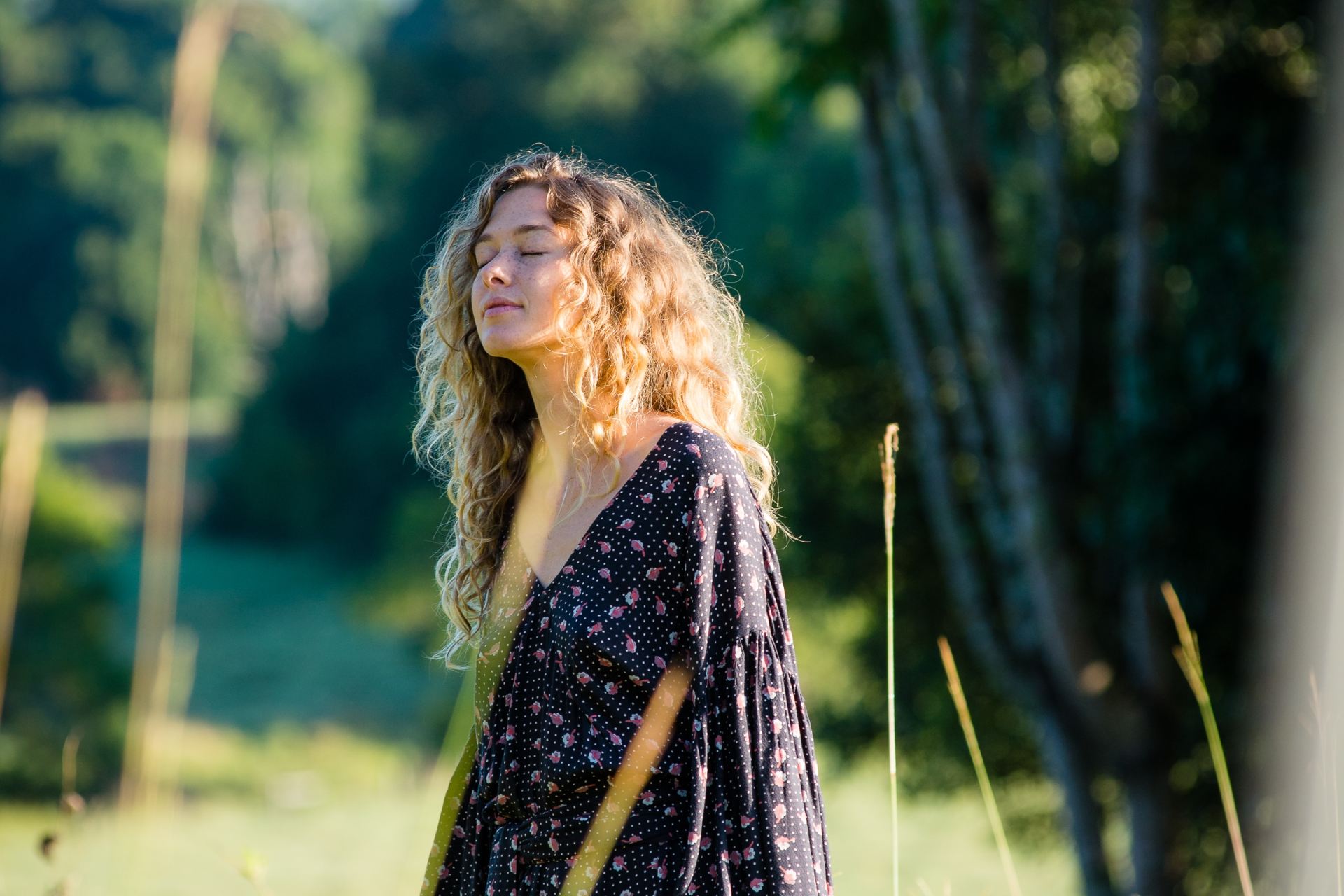 woman in black long-sleeved dress standing on grass field