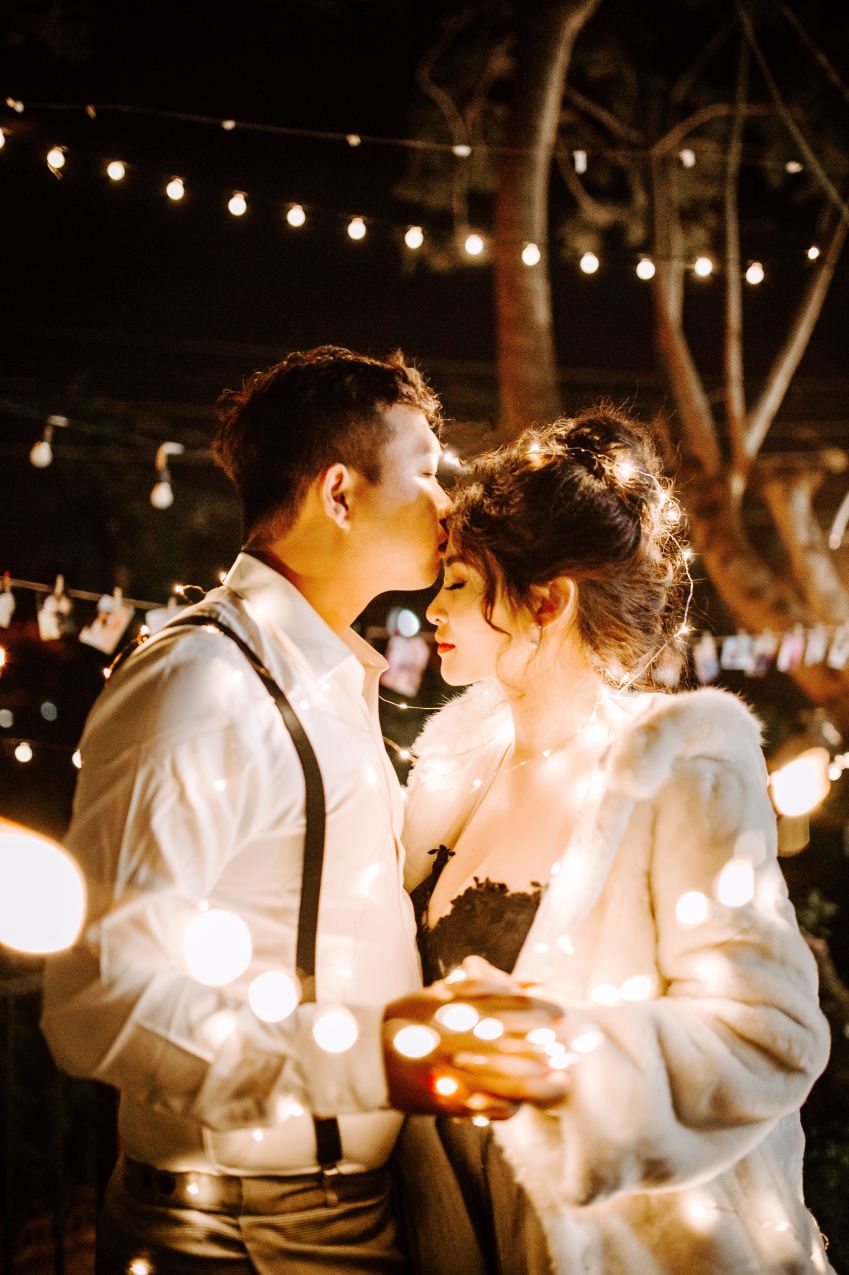 man kissing woman's forehead