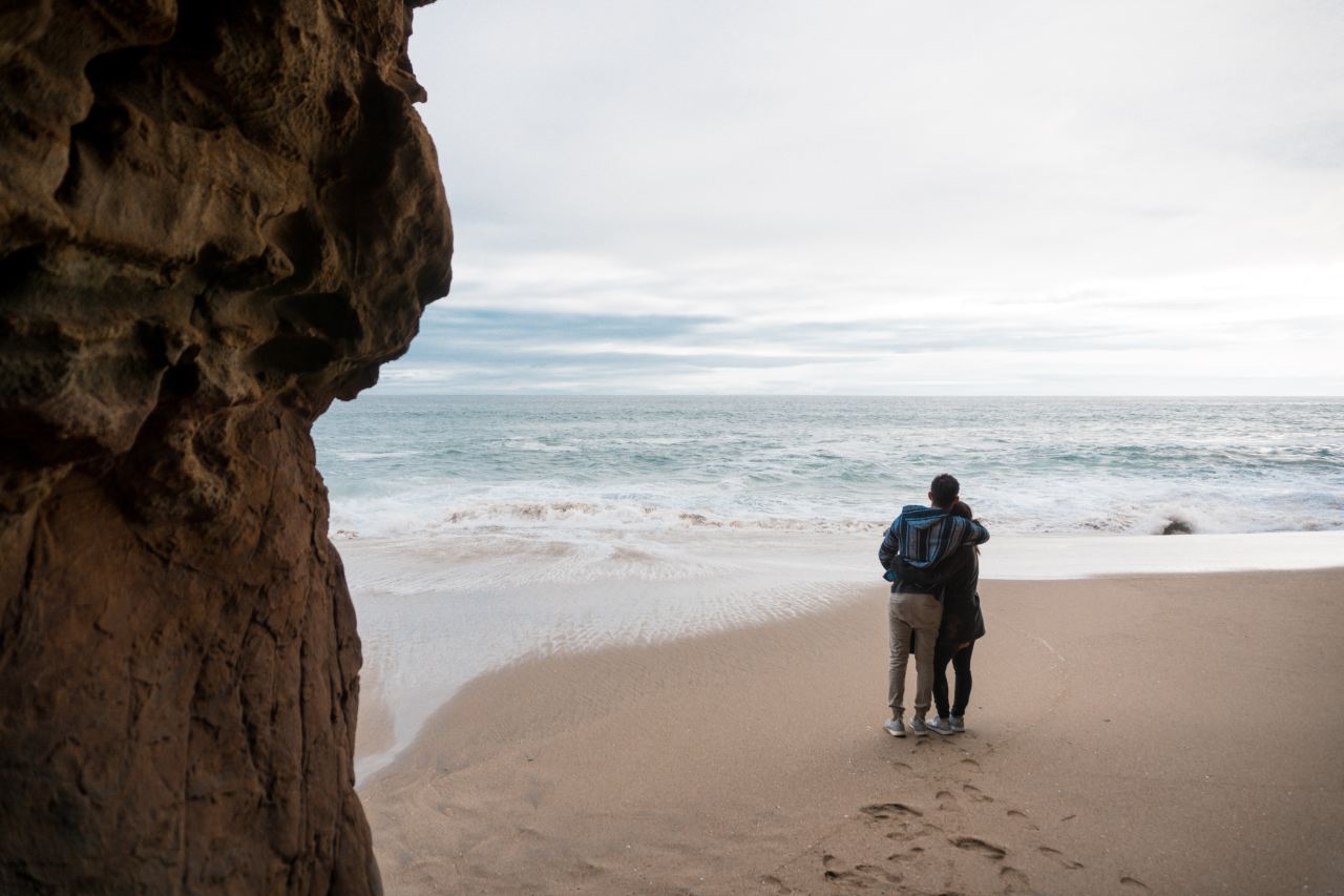 two person standing on seashore