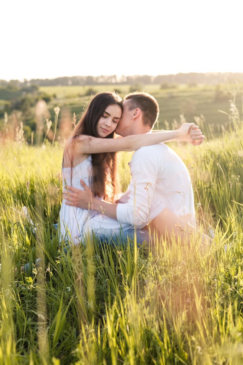 woman in white shirt sitting on green grass field during daytime