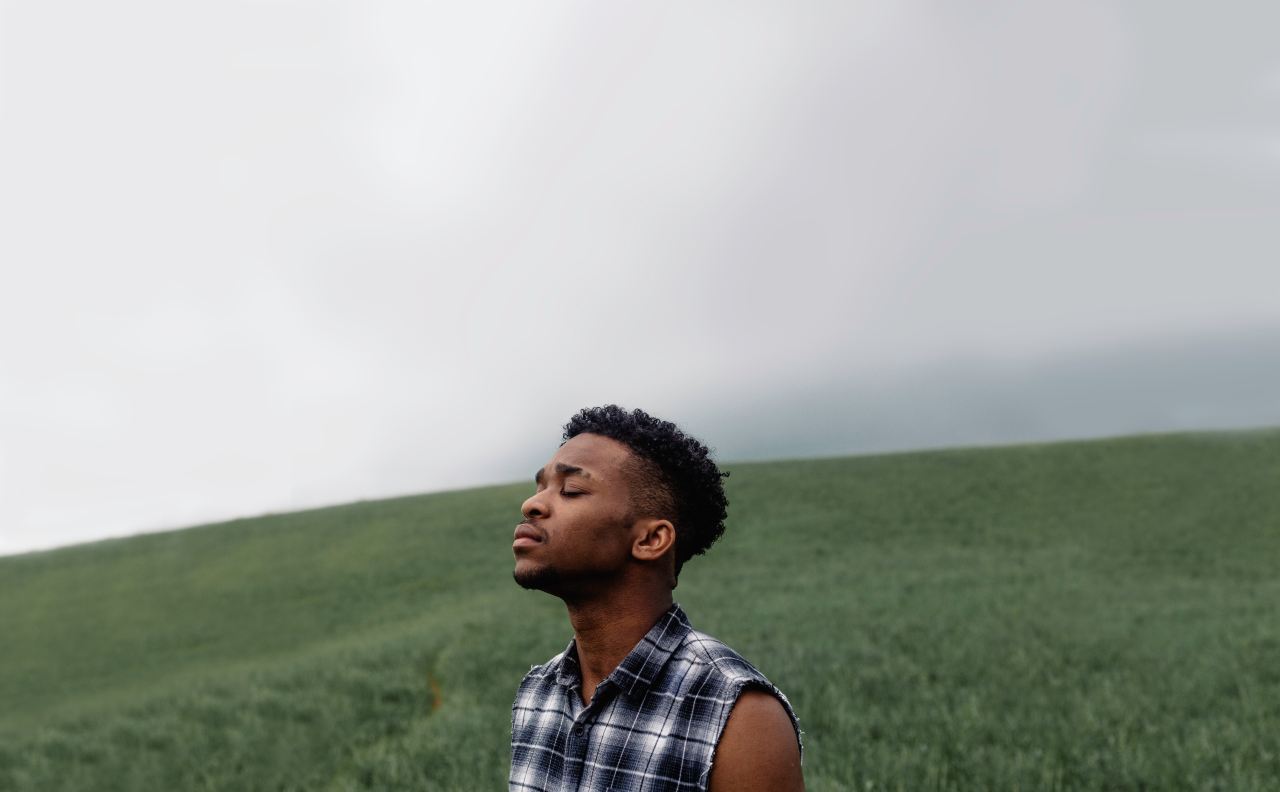 man wearing black, gray, and white plaid sleeveless top