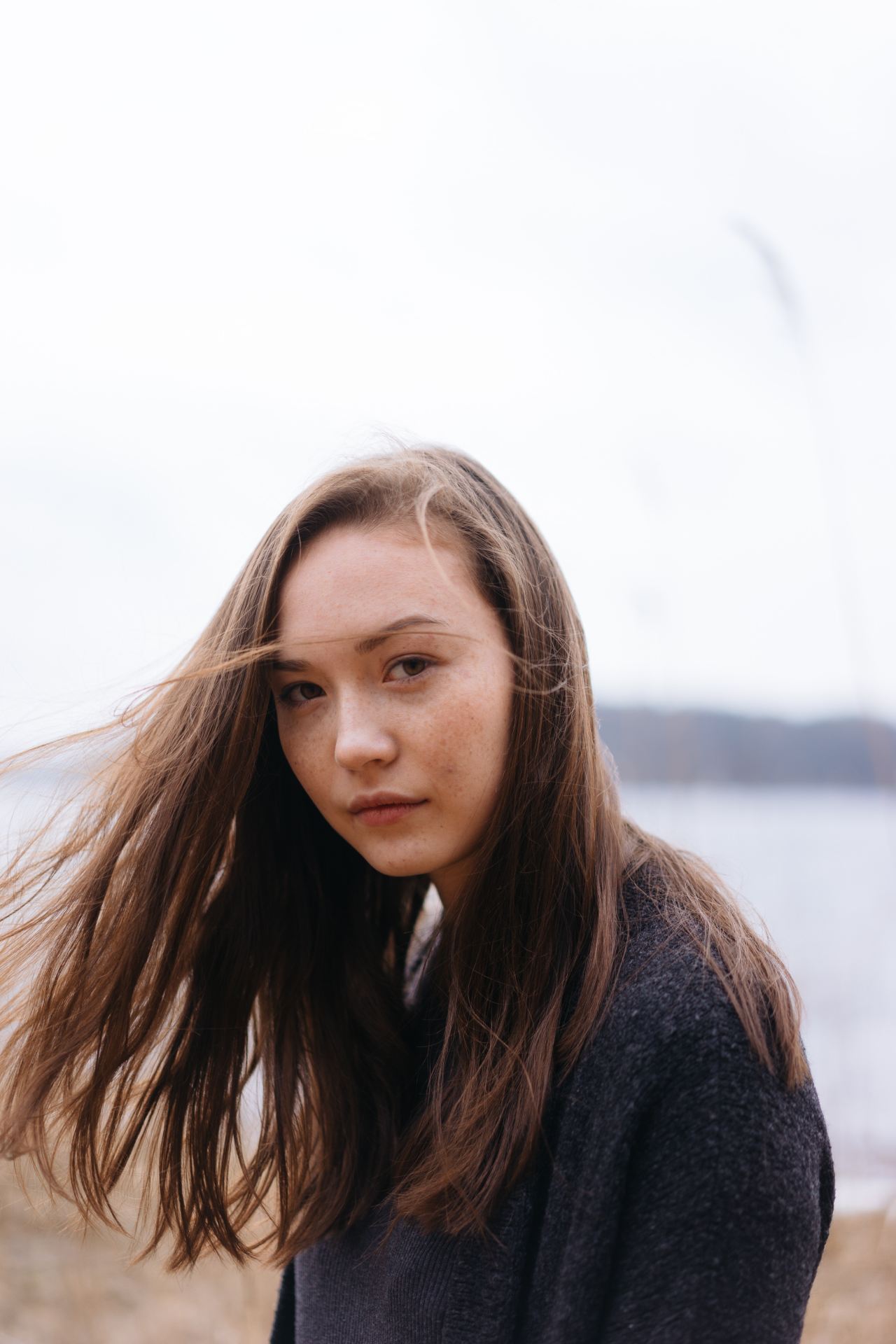 woman in black sweater on shore during daytime