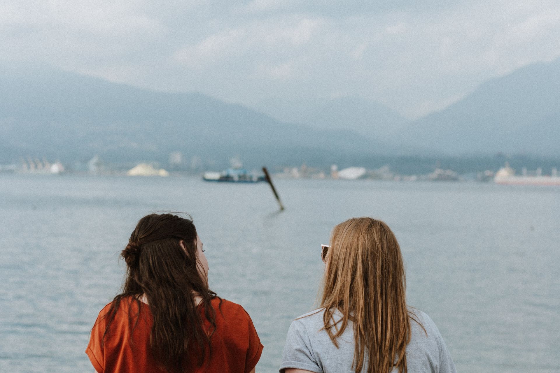 two women sitting on log