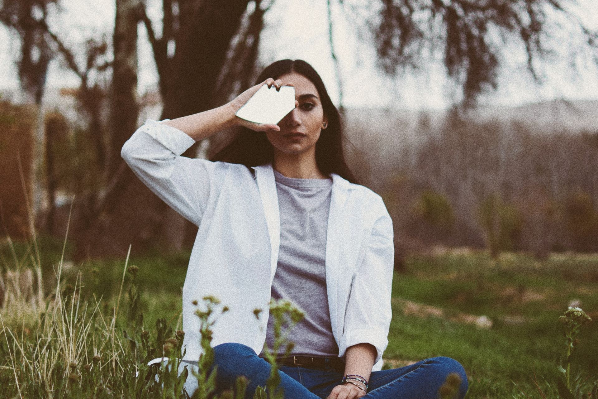 woman in white jacket sitting on grass