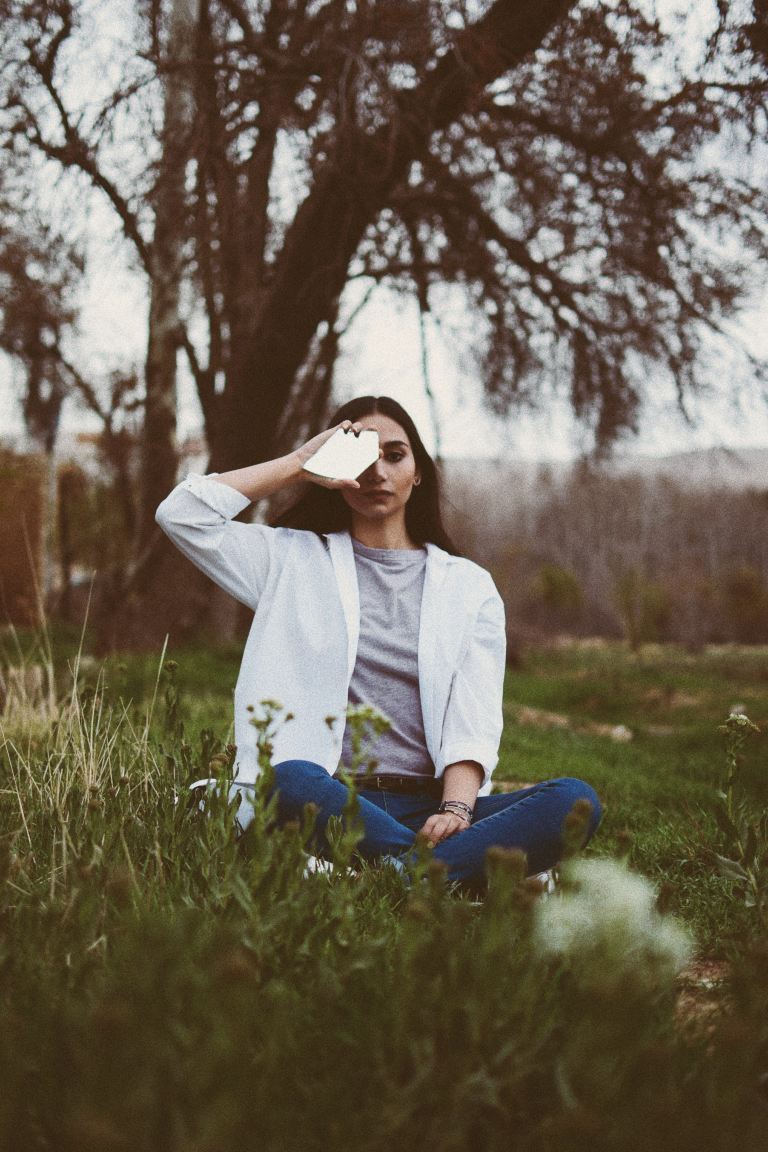 woman in white jacket sitting on grass