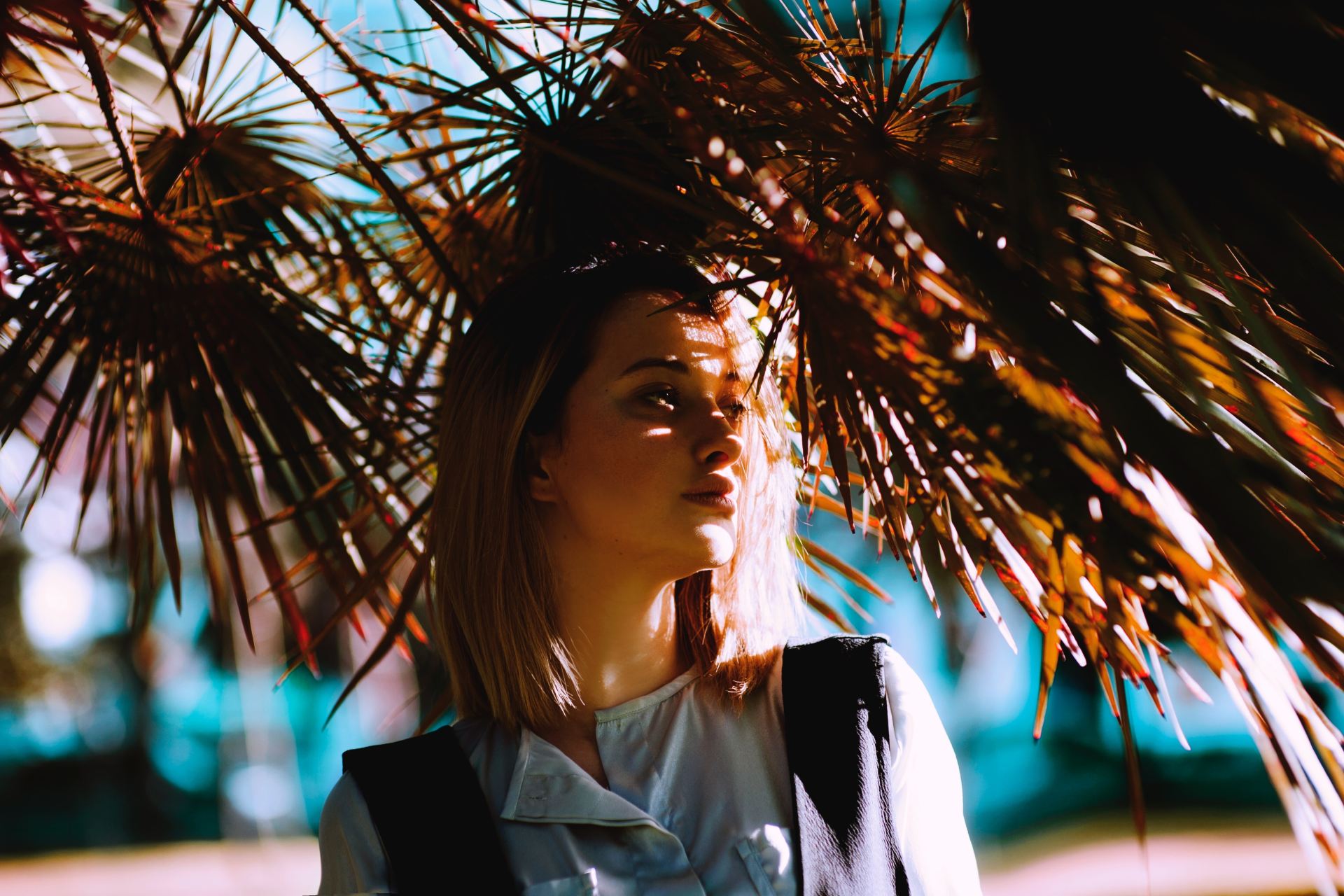 woman looking left under dried leaves