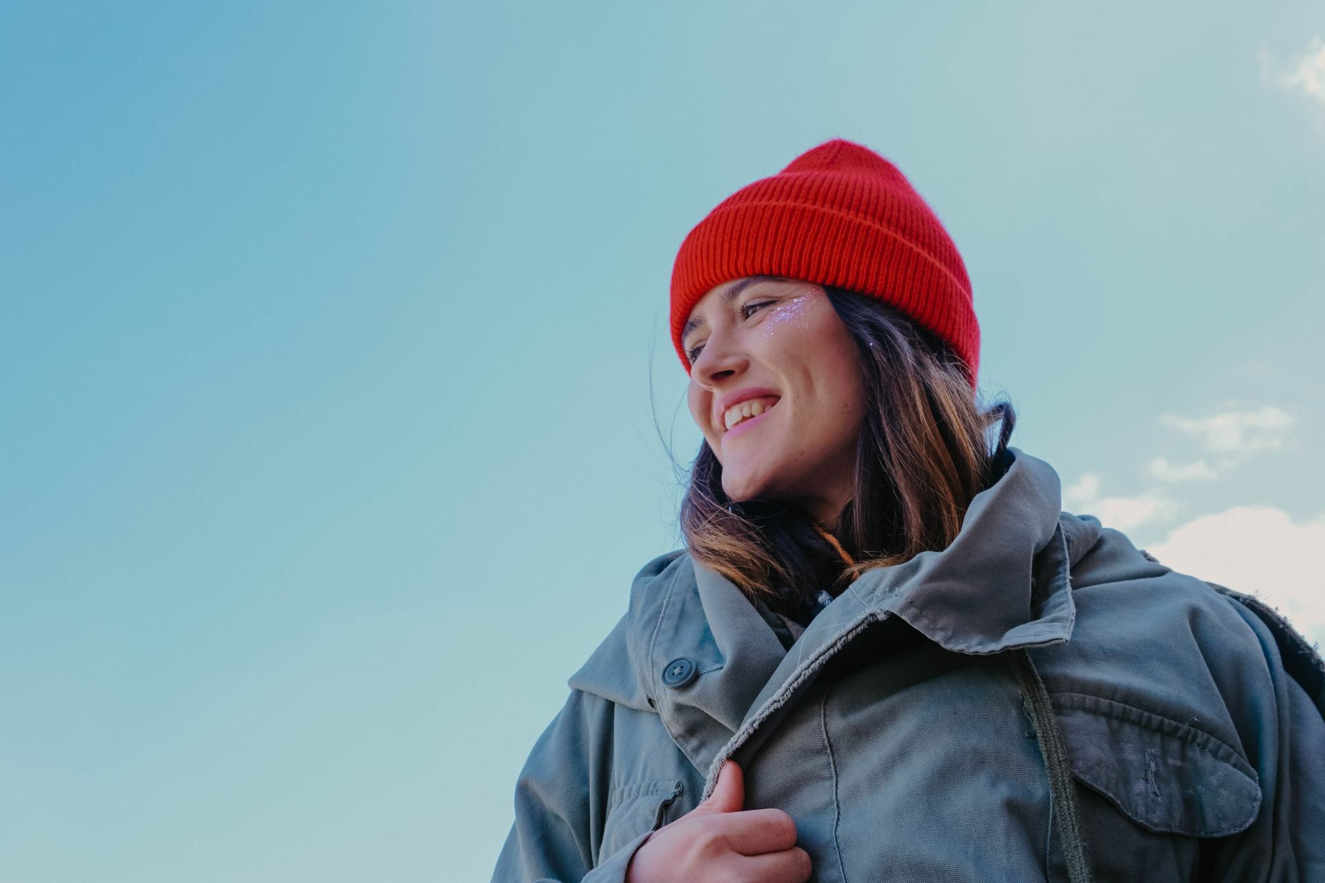 woman in gray jacket and red knit cap