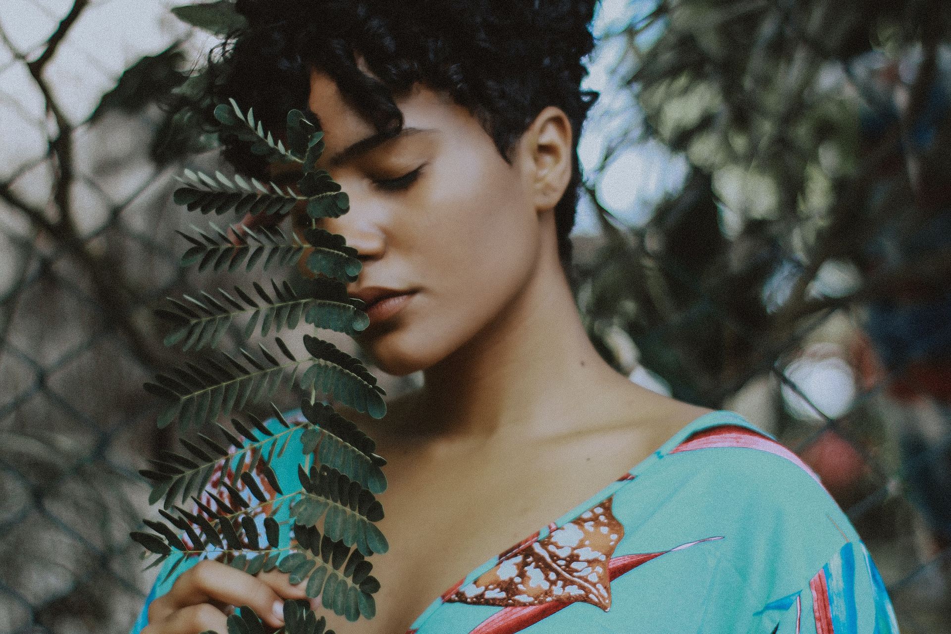 woman holding leaf beside tree