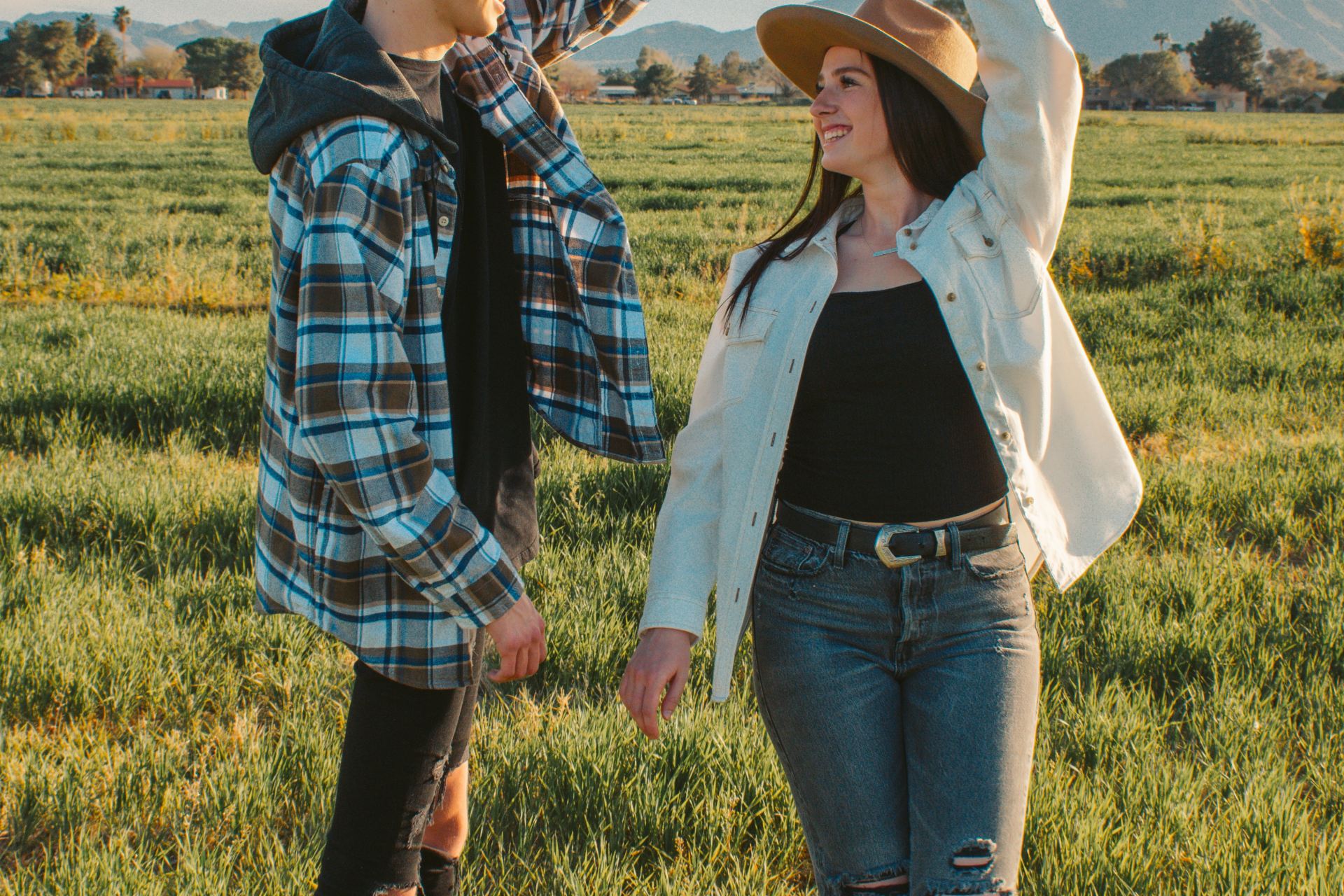 man and woman standing on green grass field during daytime