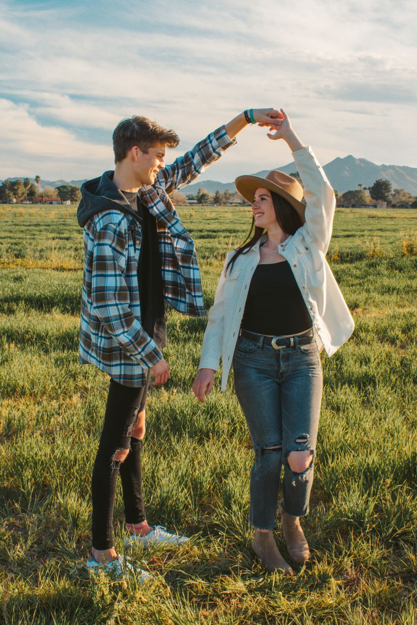 man and woman standing on green grass field during daytime