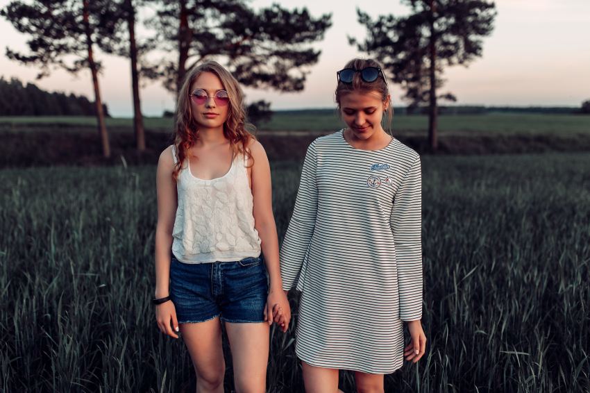 two woman walking on grass land