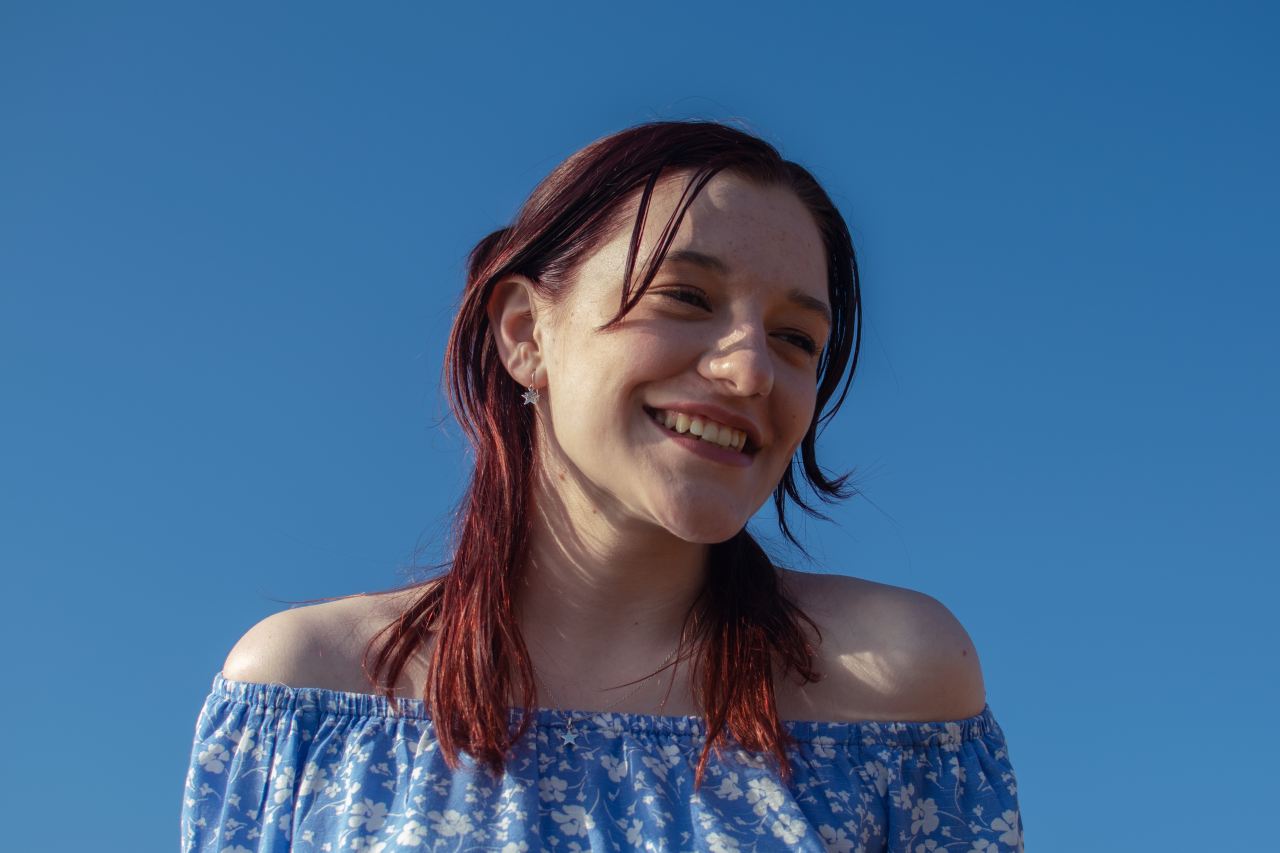 smiling woman in blue and white floral tube dress