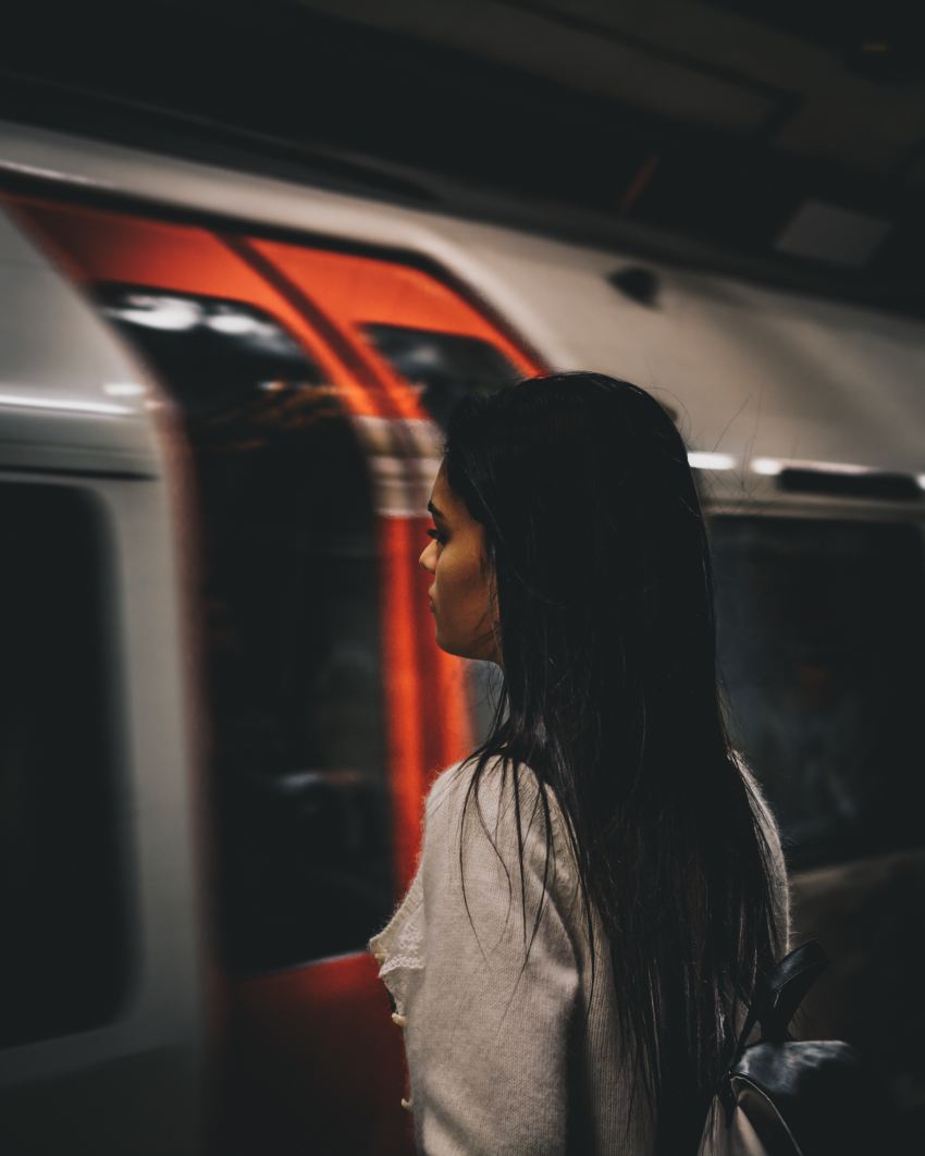 man wearing gray shirt standing in front of train