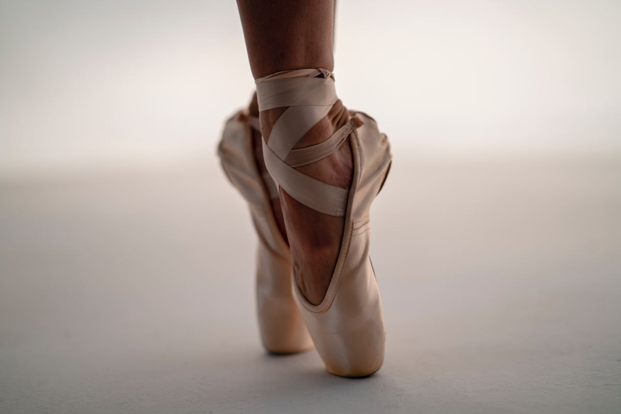 person in white ballet shoes