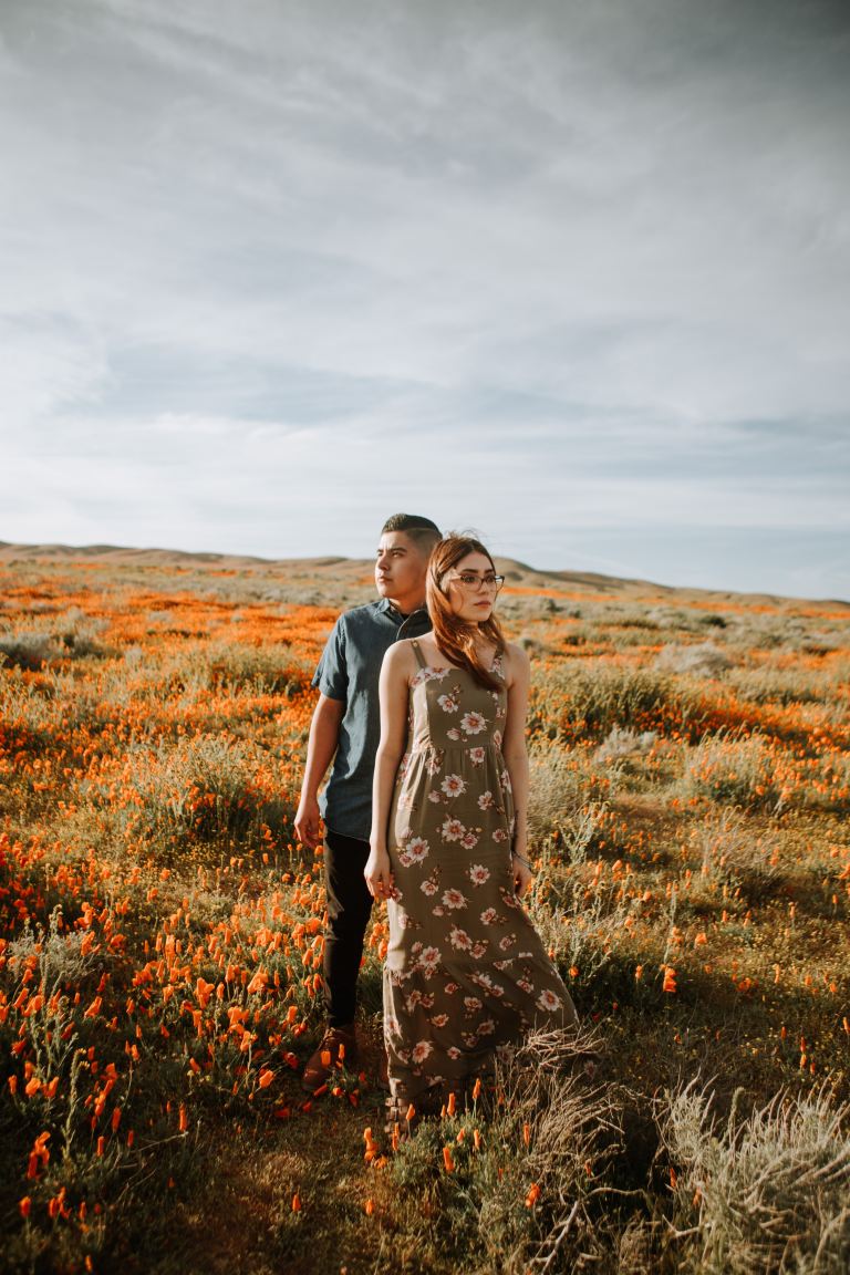 woman in black and white floral dress standing on brown grass field during daytime