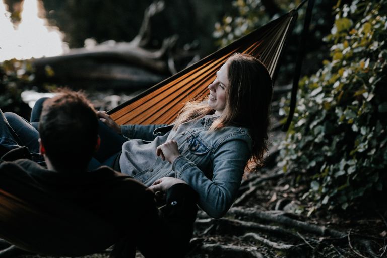 man and woman lying on hammock