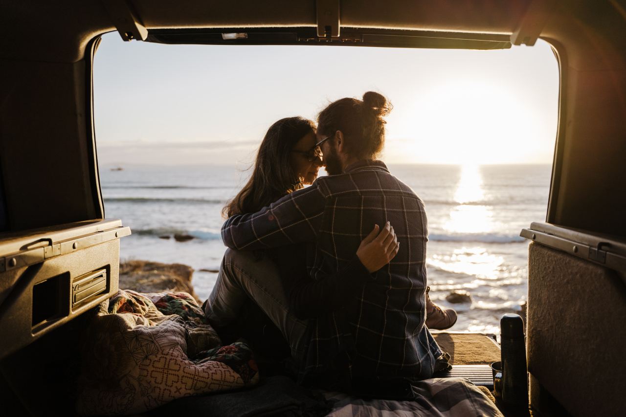 man and woman sitting on the beach during daytime