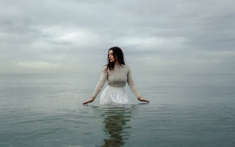 woman in white dress standing on water