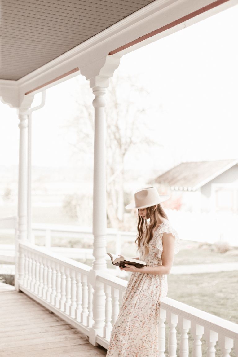 woman in white dress standing on white wooden bridge during daytime