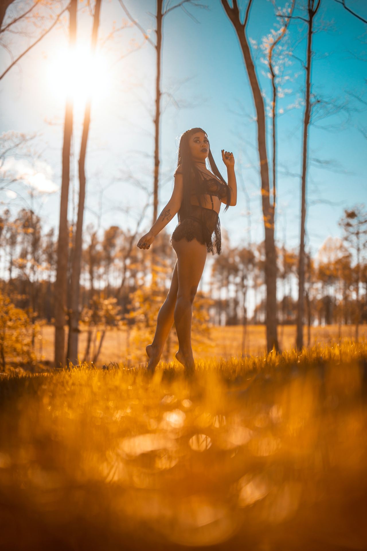 woman in black dress standing on grass field during daytime