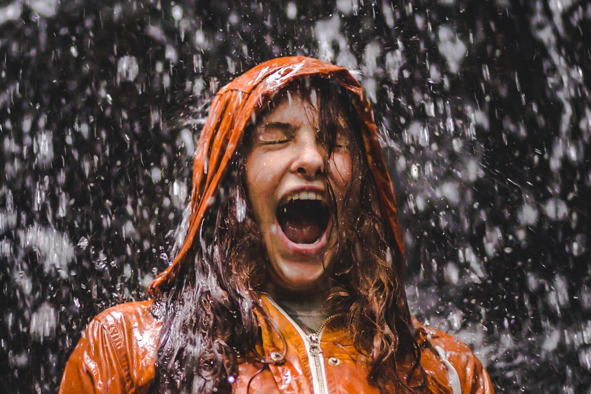 close-up photo of woman in orange coat