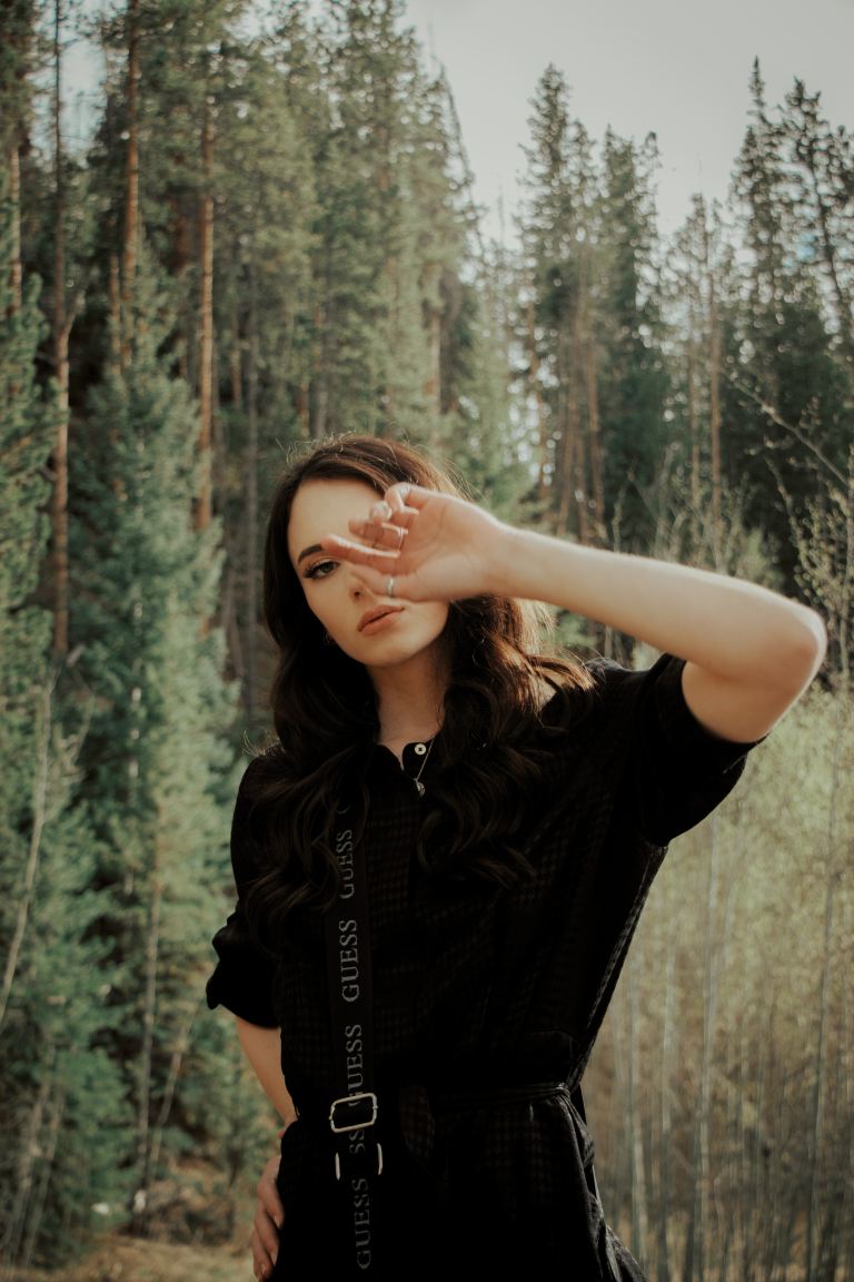 woman in black t-shirt standing in forest