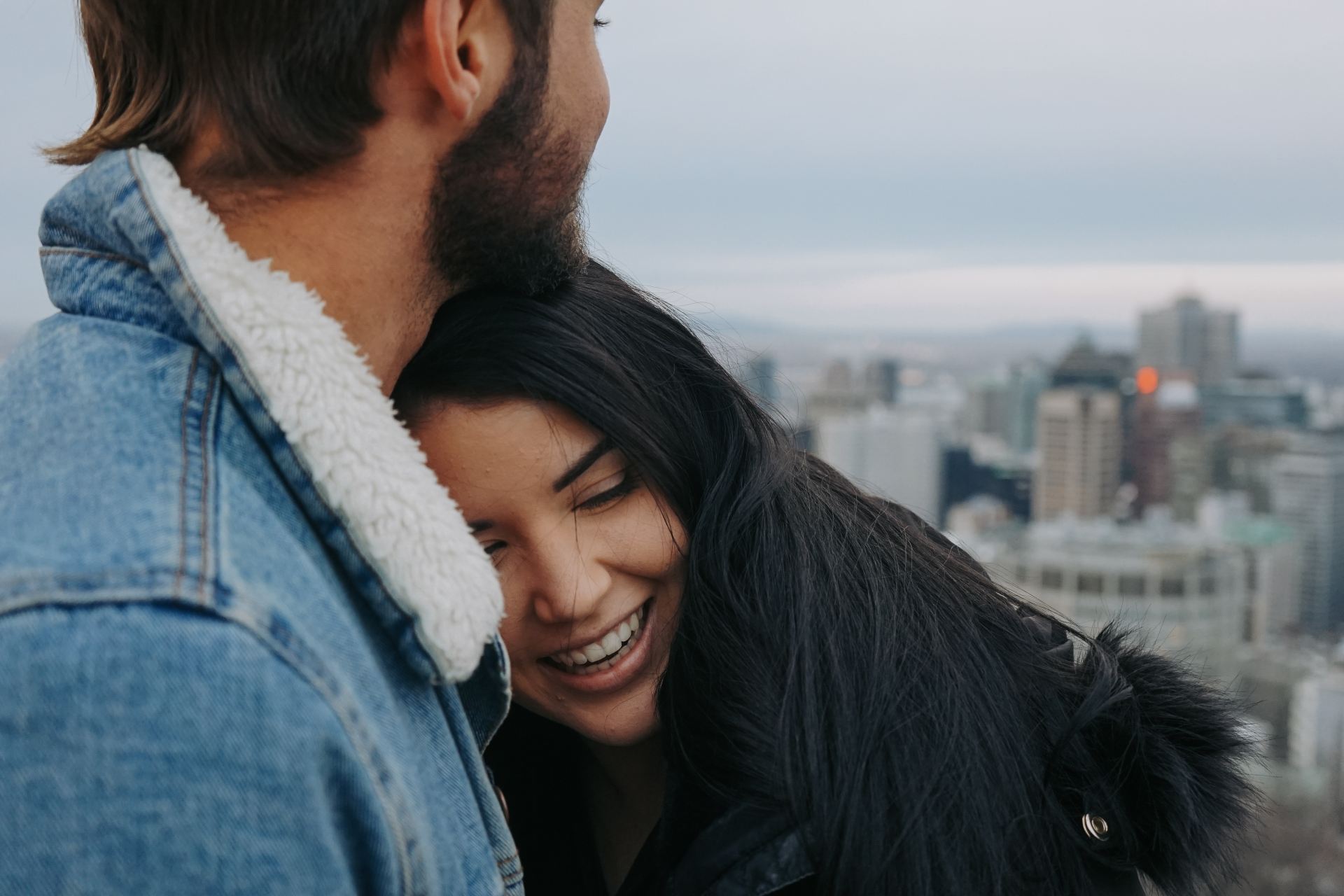 man and woman cuddling on rooftop