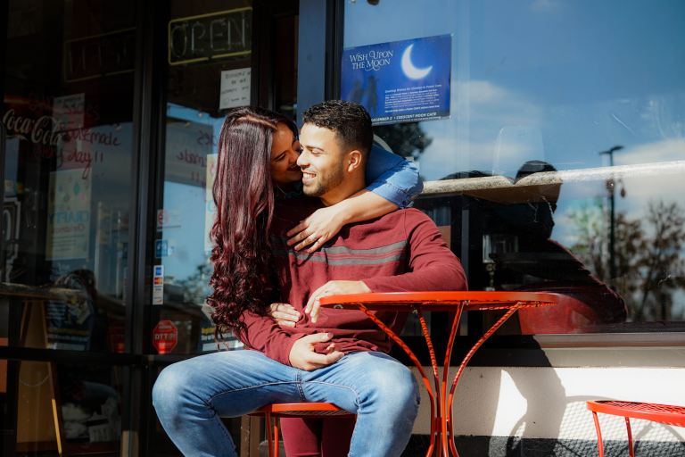 woman kissing man's cheek at daytime