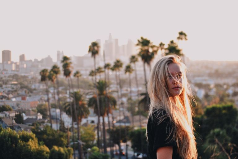 woman standing near palm trees at daytime