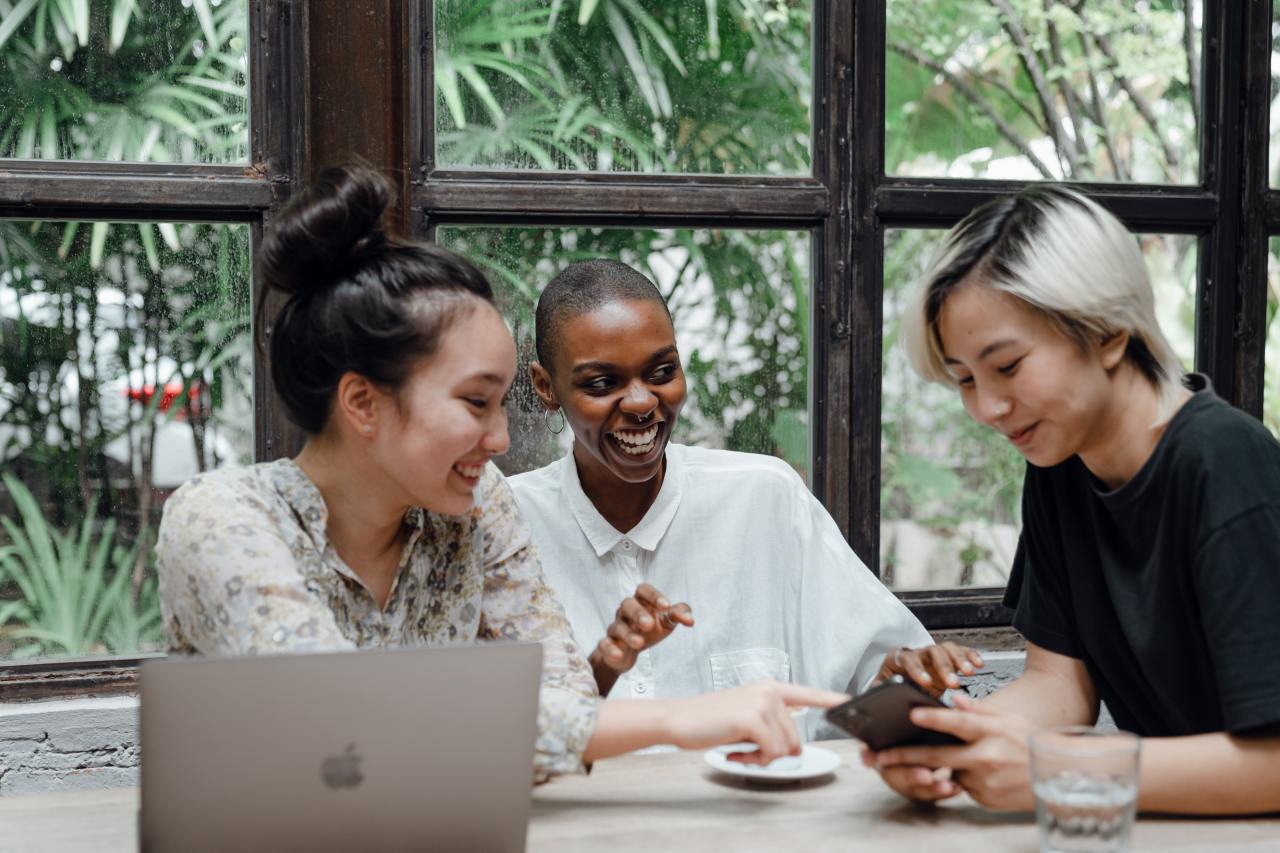 group laughing by laptop