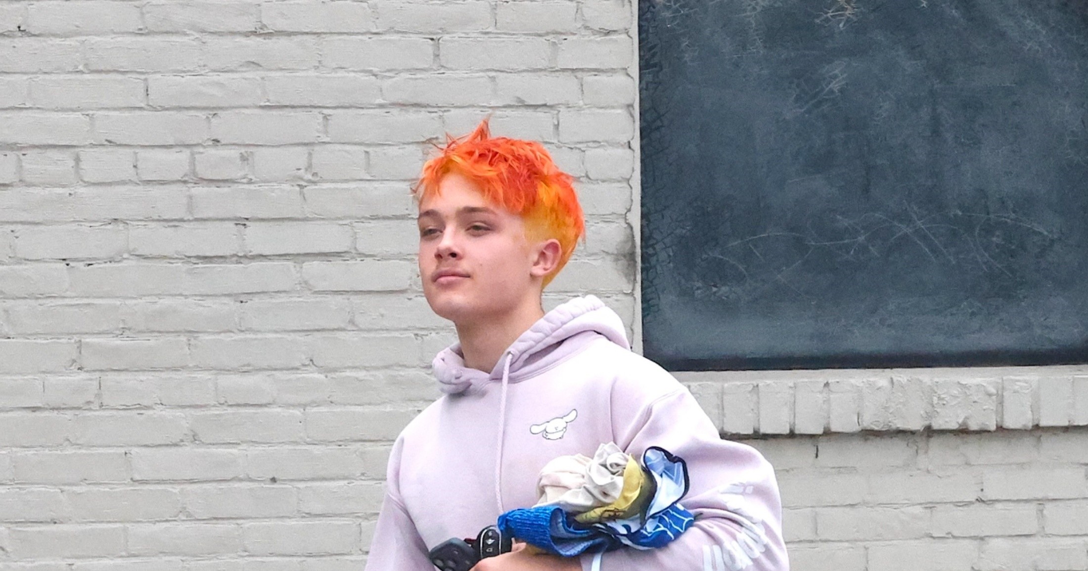 Knox Jolie-Pitt with bright orange hair exiting a gym