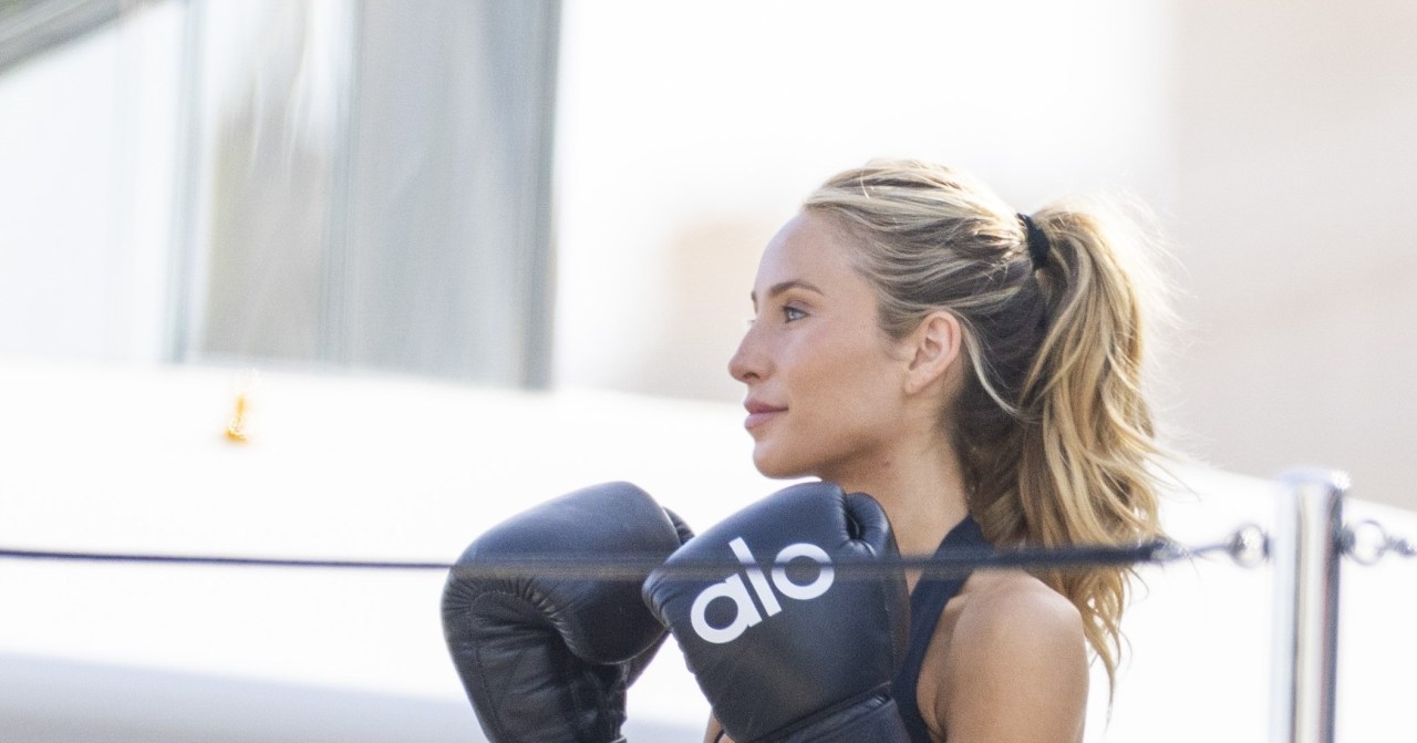 Alix Earle in boxing gloves hitting pads on a yacht deck in Monaco, with friends Jake Shane and Stassie Karanikolaou
