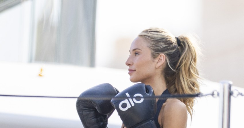 Alix Earle in boxing gloves hitting pads on a yacht deck in Monaco, with friends Jake Shane and Stassie Karanikolaou