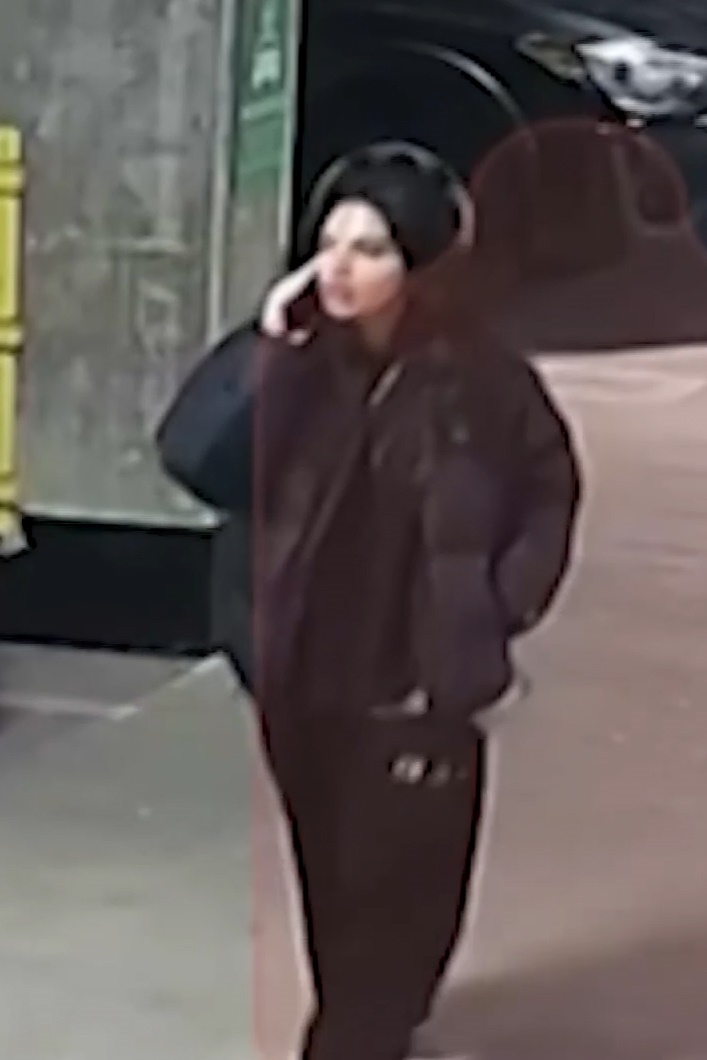 Surveillance footage of Huda Mustafa walking through an apartment complex while talking on her phone
