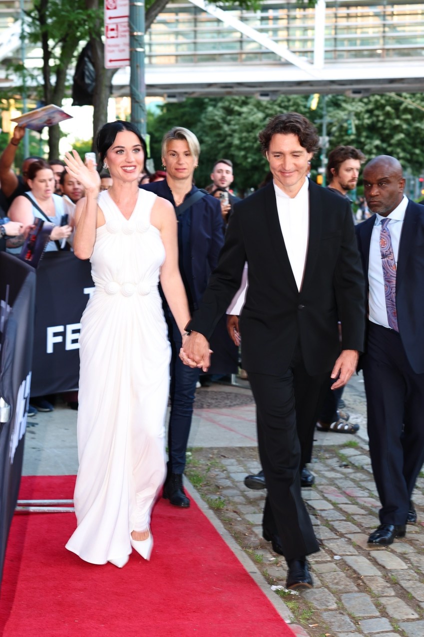 Katy Perry in a white gown and Justin Trudeau in a black suit posing on the red carpet at the Tribeca Festival in New York City