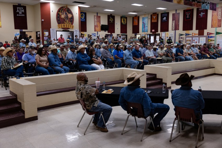 Crowd of people seated at an informational meeting inside Cotulla High School in Texas