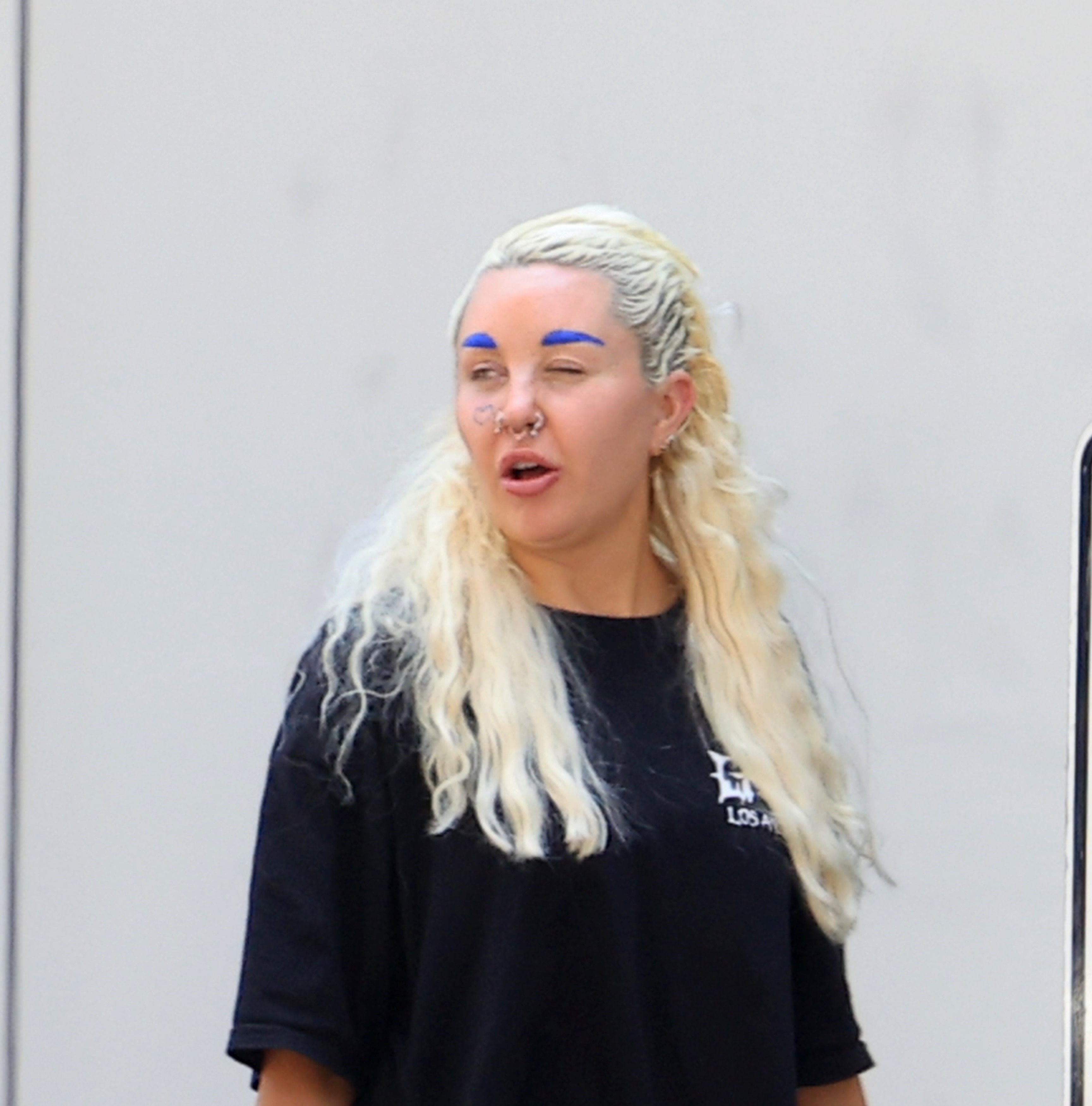 Amanda Bynes with blue eyebrows and a gold bottom grill out in Los Angeles with her boyfriend Zachary