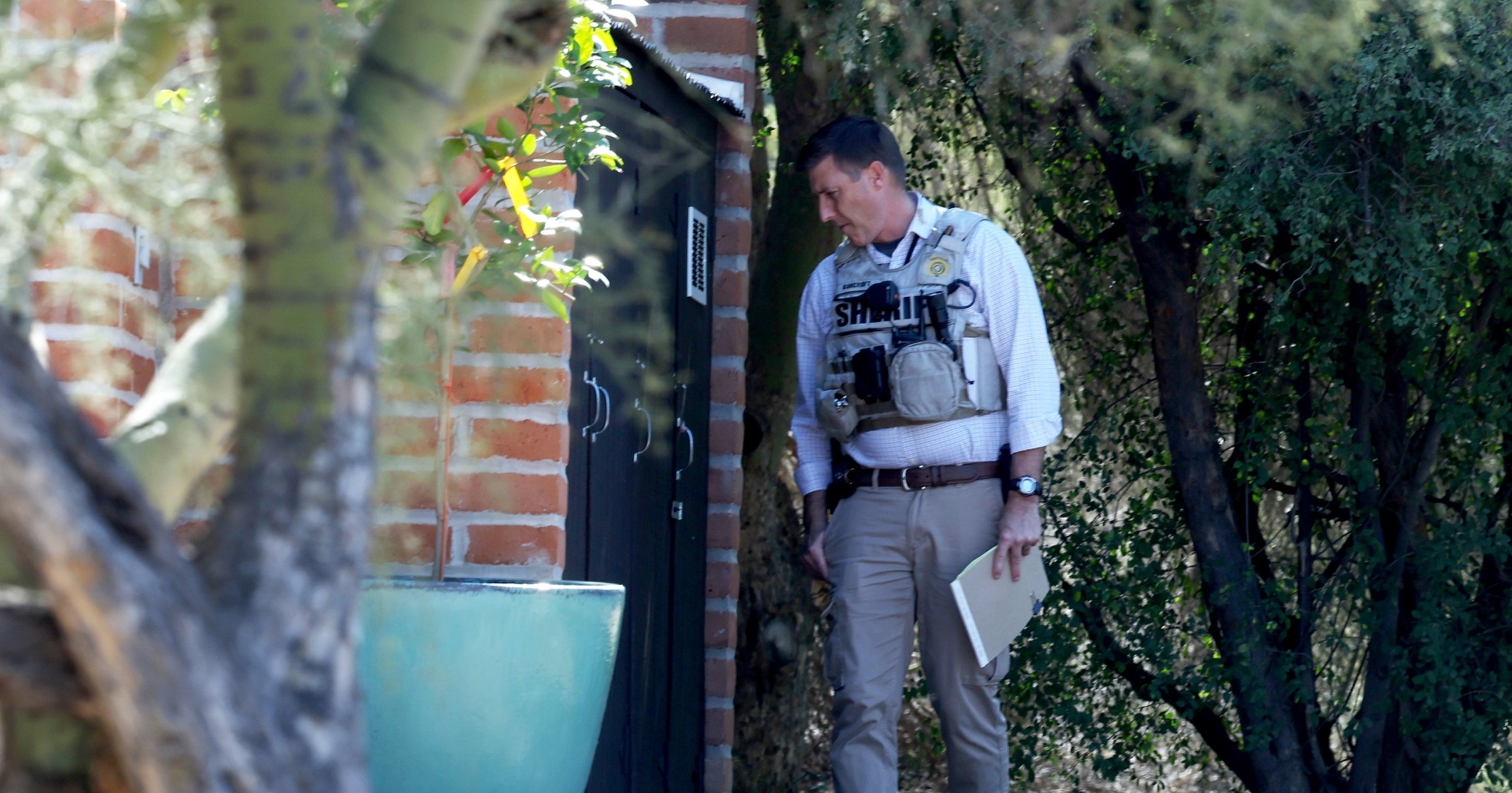 Sheriff's deputies leaving Nancy Guthrie's house after searching a covered hole in the garden