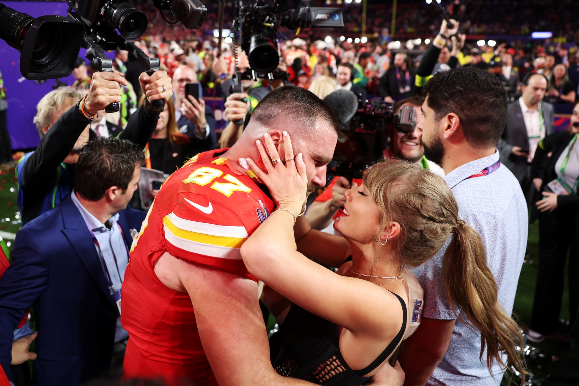 Taylor Swift and Travis Kelce embracing on the field at Allegiant Stadium after the Kansas City Chiefs won Super Bowl LVIII