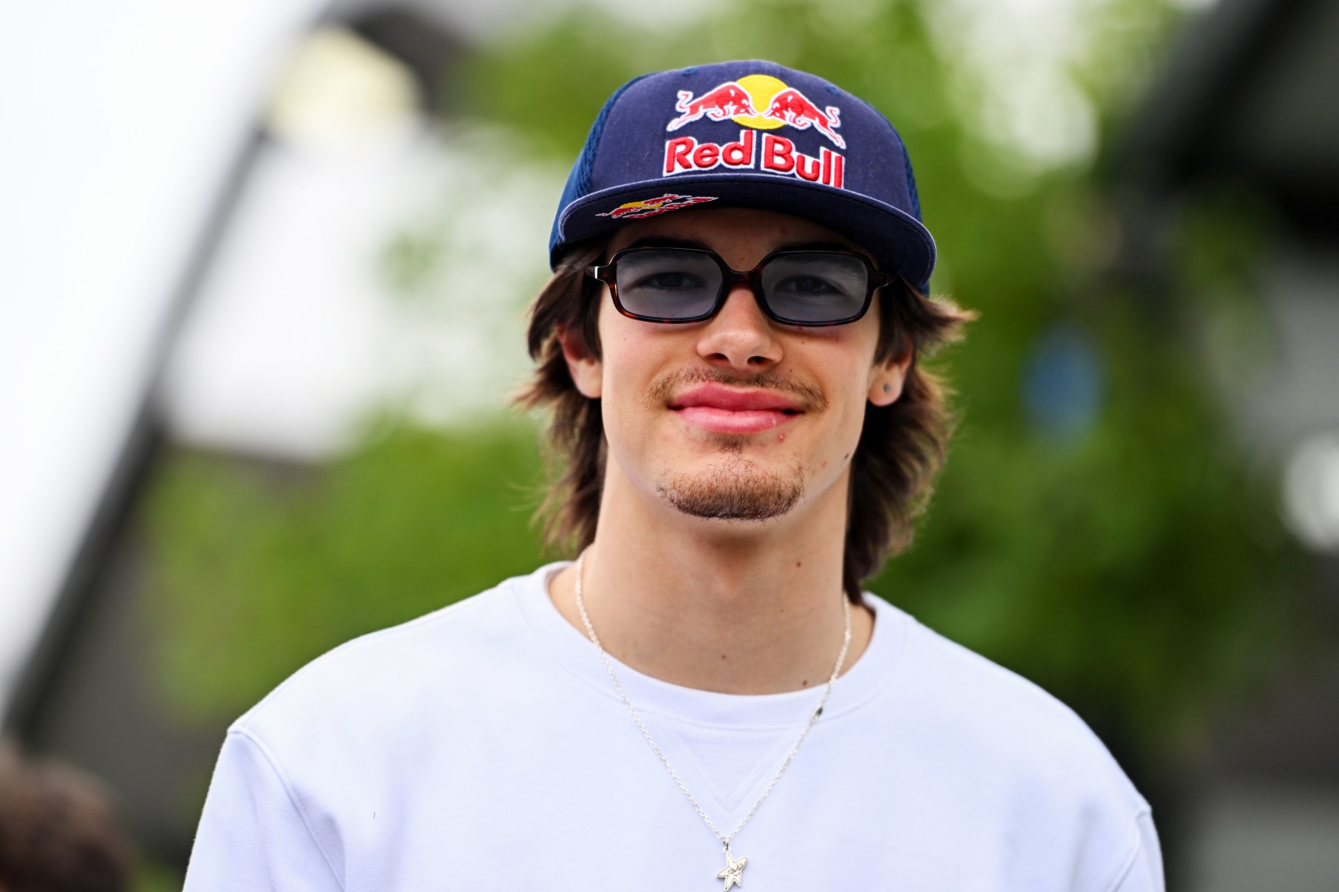 Nikola Tsolov wearing a Red Bull cap and sunglasses, smiling at Albert Park during Australian GP previews.