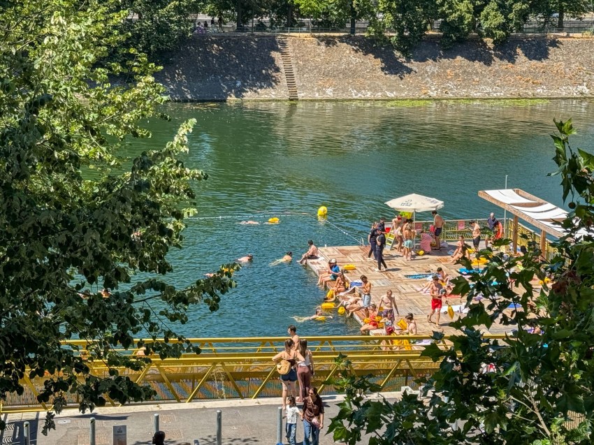 Wide shot of the Grenelle supervised swimming area along the Seine riverbank in Paris's 15th arrondissement, with a platform and marked-off swimming zones