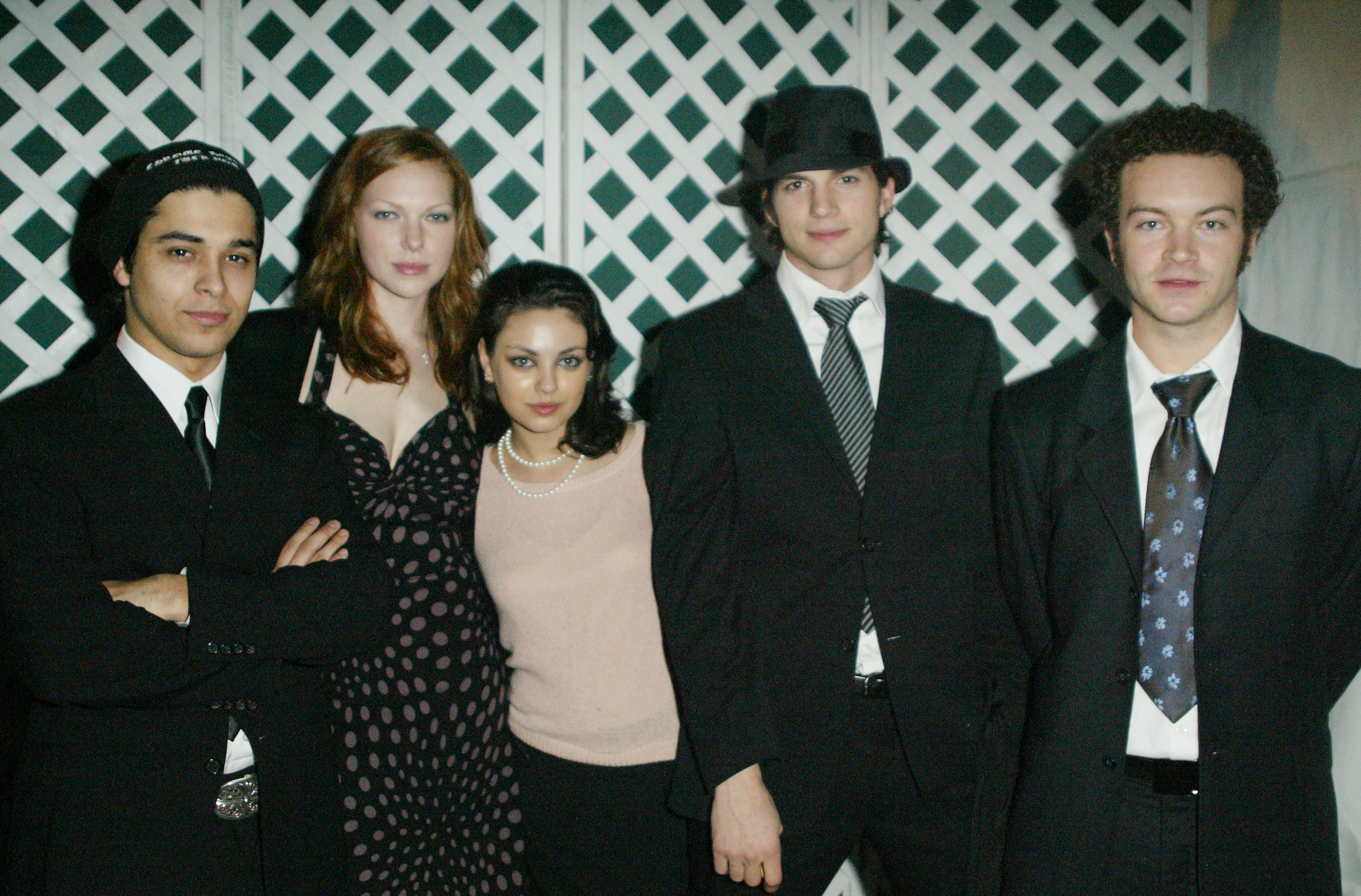 Wilmer Valderrama, Laura Prepon, Mila Kunis, Ashton Kutcher, and Danny Masterson posing backstage at a Hollywood fundraiser in 2003