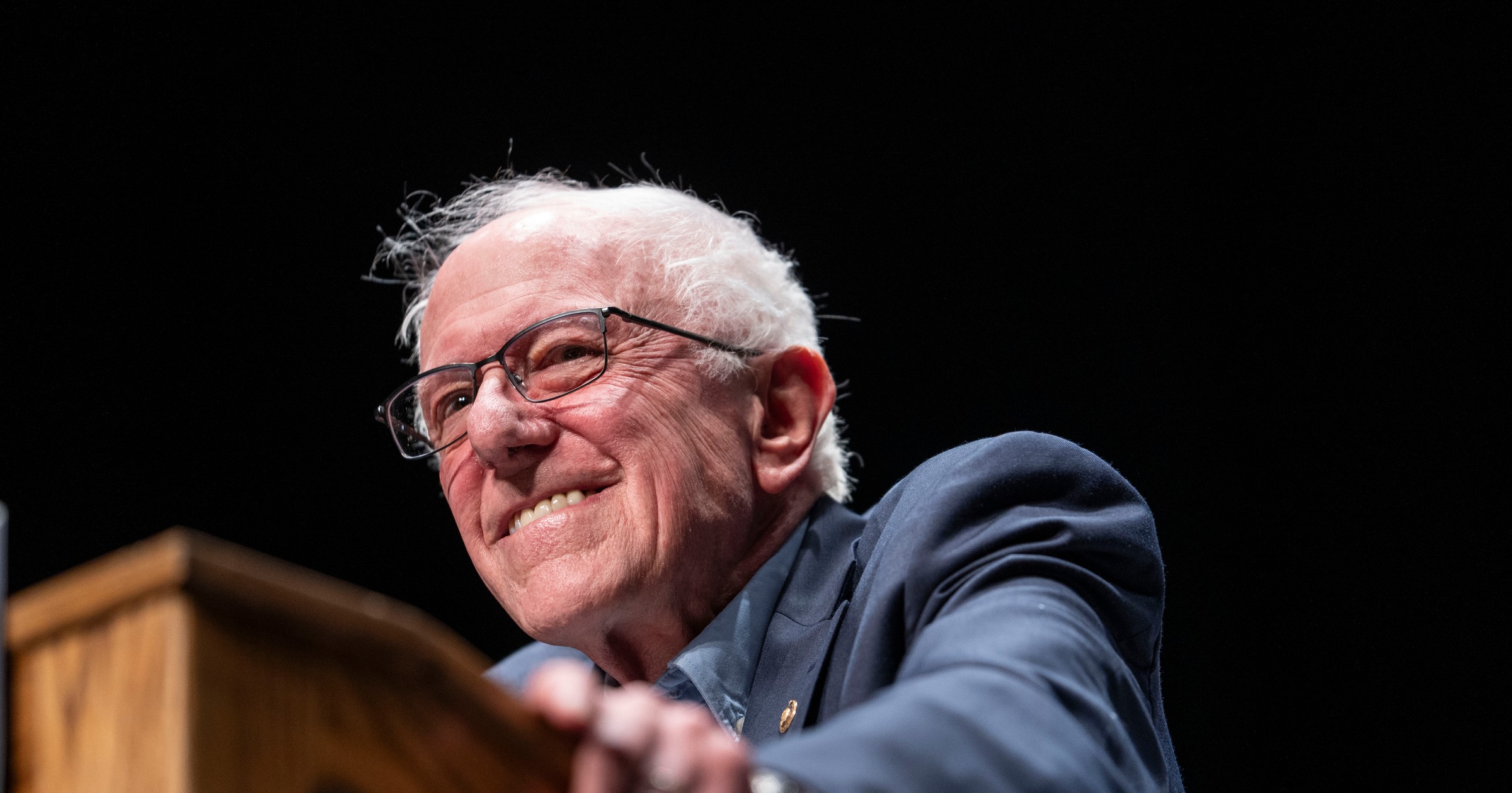Bernie Sanders speaking at a rally inside the Detroit Opera House, with Alexandria Ocasio-Cortez and Abdul El-Sayed in attendance