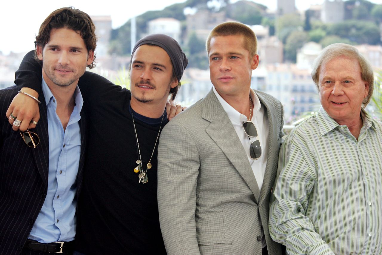 Four men posing together outdoors at a film festival photo call, with a hillside town visible behind them.