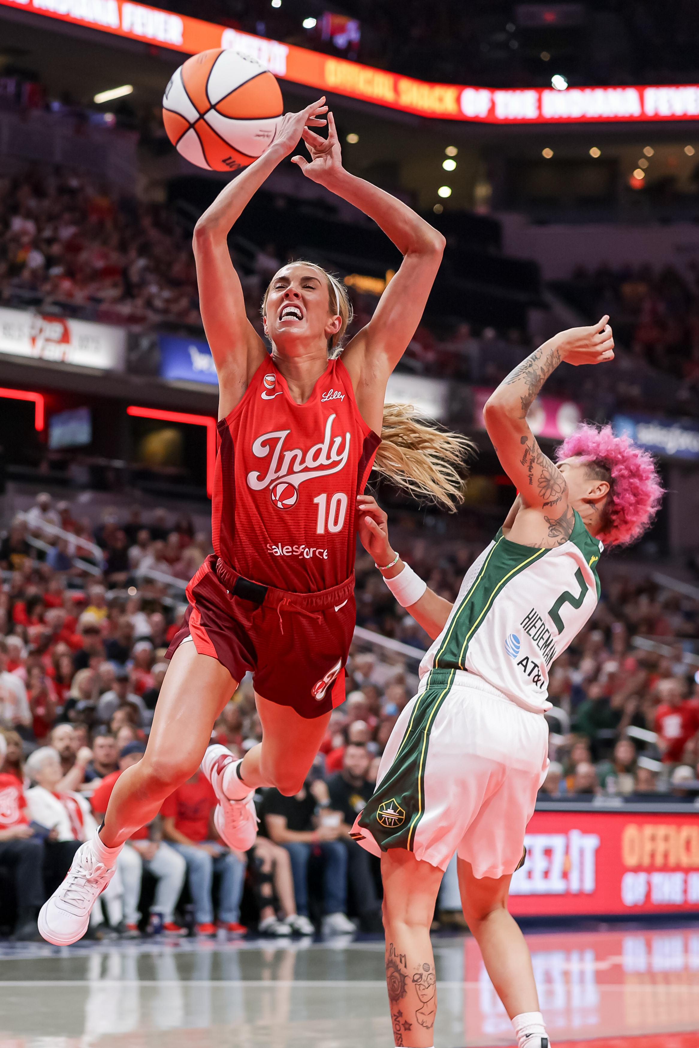 Indiana Fever's Lexie Hull (#10) leaps and loses the ball while defended by Seattle Storm's Natisha Hiedeman (#2) during a WNBA game at Gainbridge Fieldhouse.