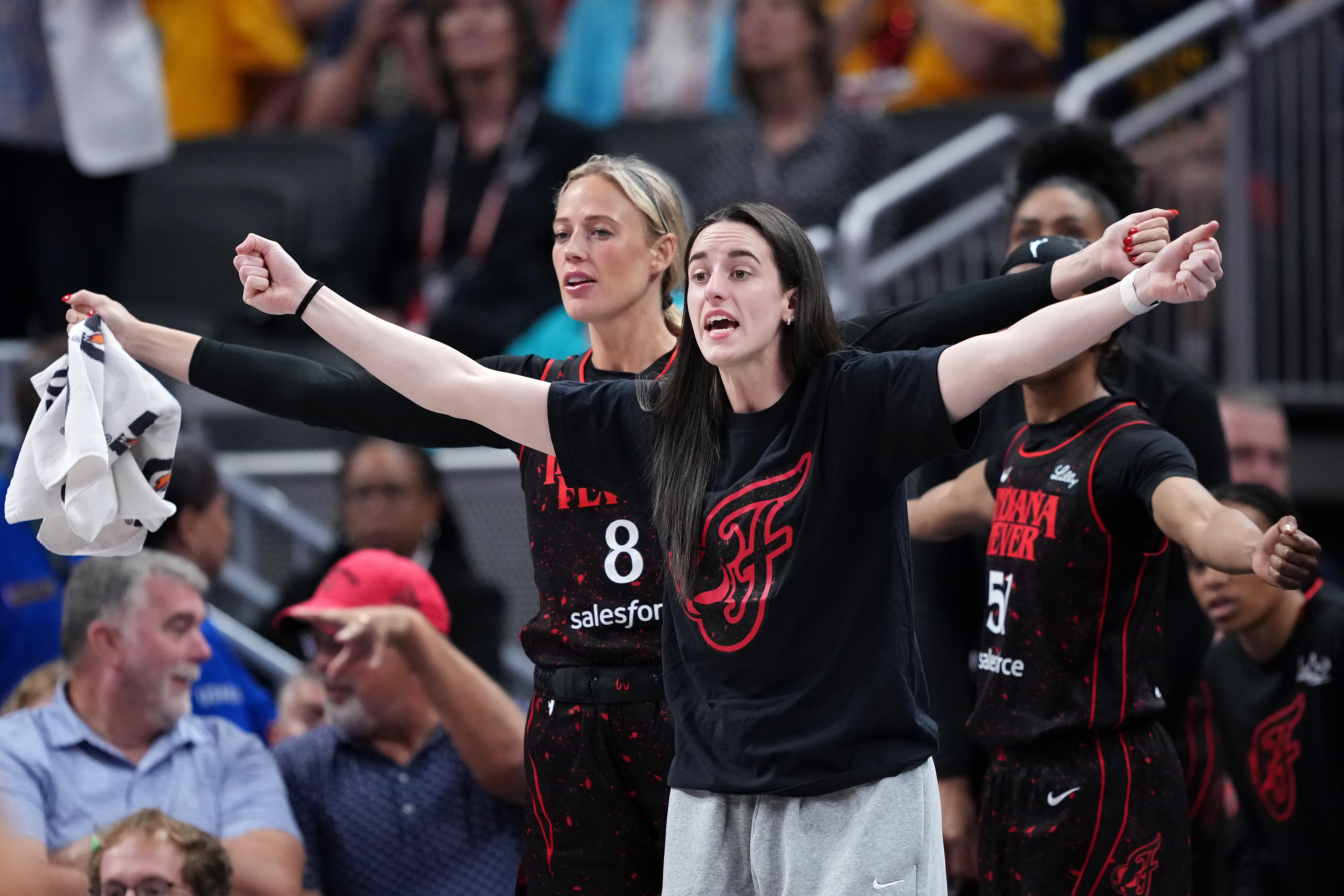 Sophie Cunningham and Caitlin Clark sitting on the Indiana Fever bench during a game against the Phoenix Mercury