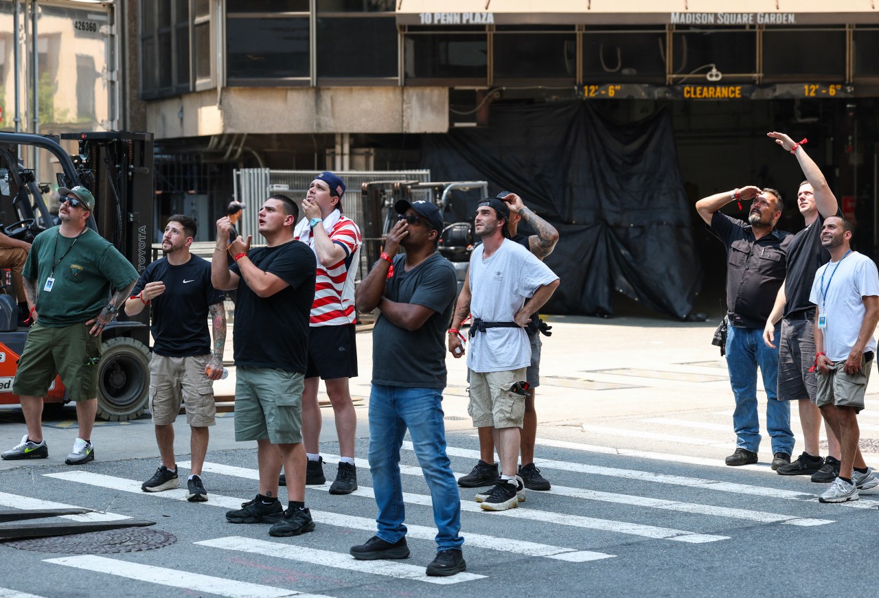 People on a New York City street looking up at the Empire State Building